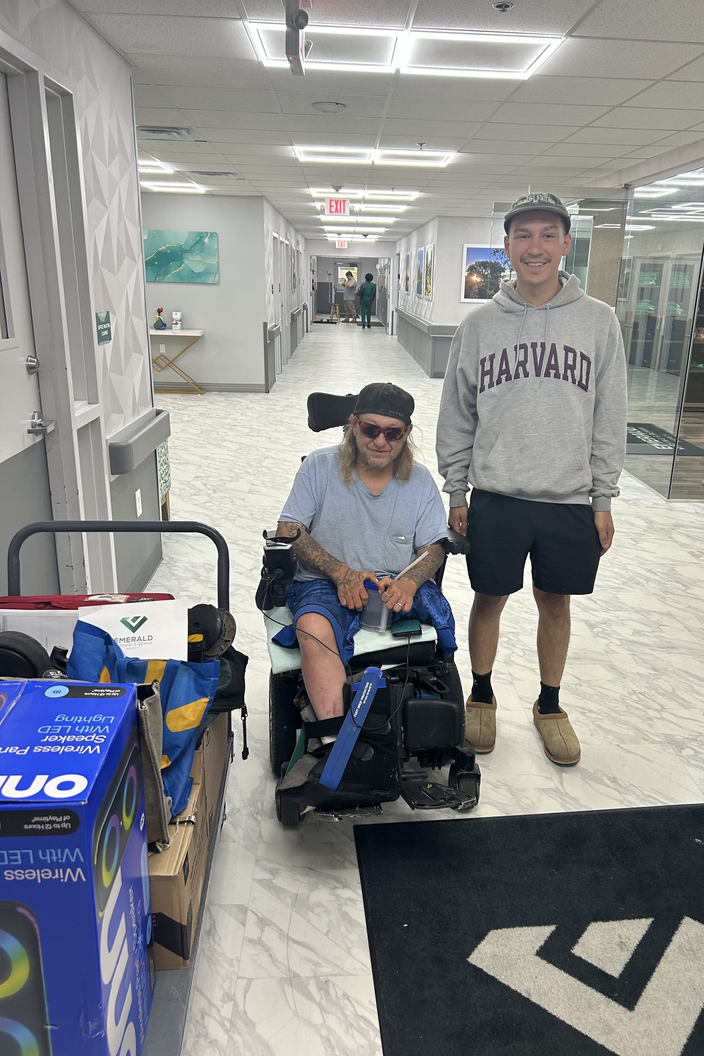 The owner’s son alongside a client in a power wheelchair